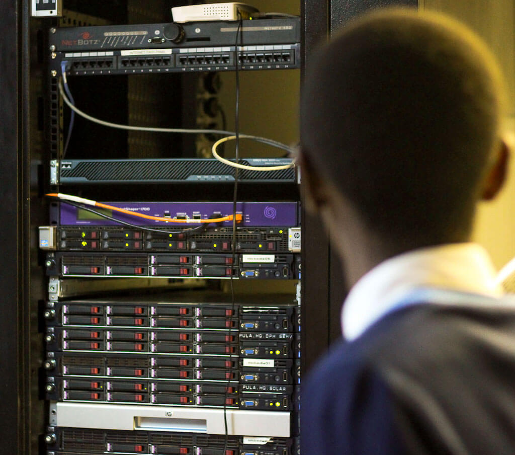 Young student boy looking at computer servers